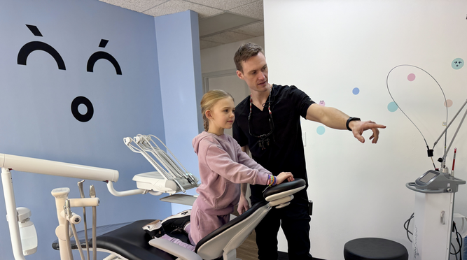 compassionate dentist educating nine year old girl about her growth and oral hygiene